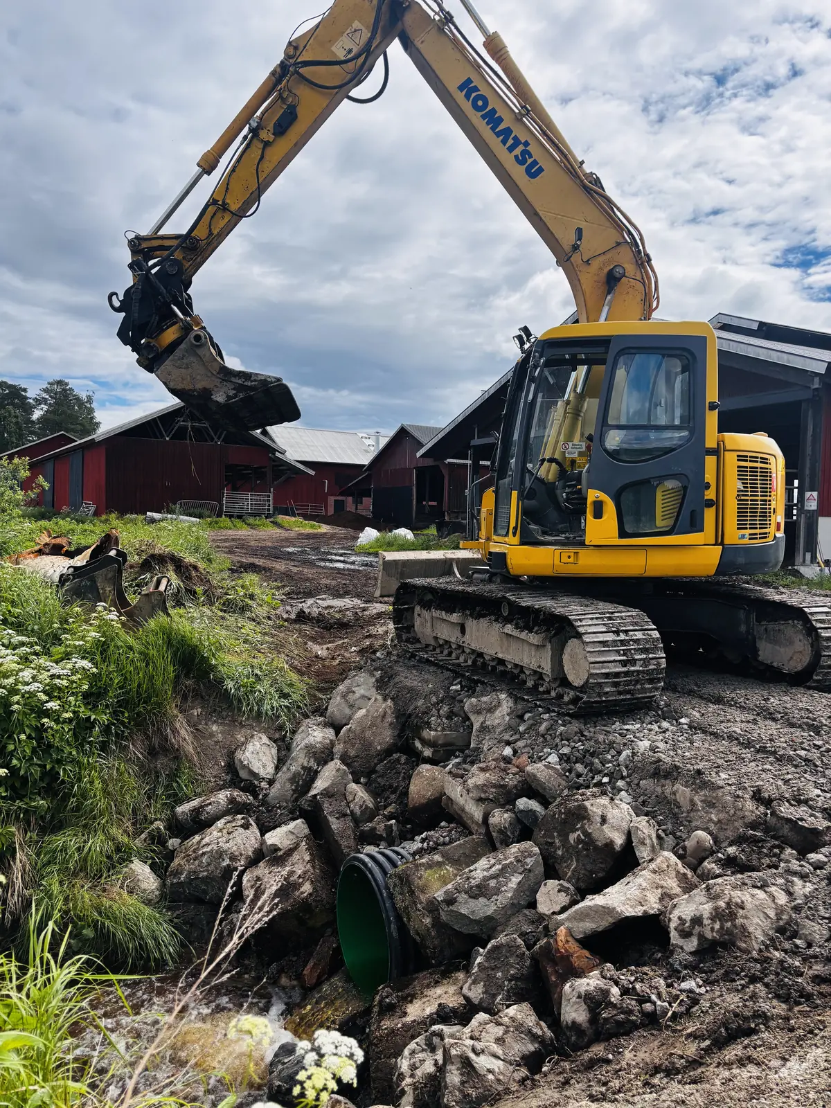 Grävmaskin vid schakt på gårdsplan